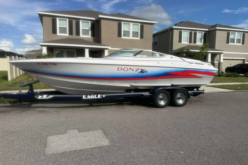 The Image of 2006 Donzi 26 boat on trailer in suburban neighborhood. - 1