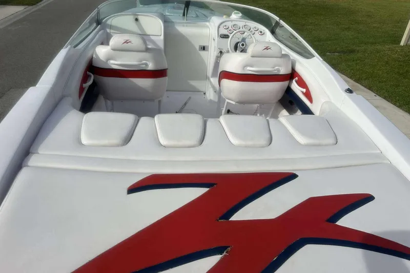 Slide: The Image of 2006 Donzi 26 boat interior with white and red seating, sleek dashboard, and logo detail. - 4