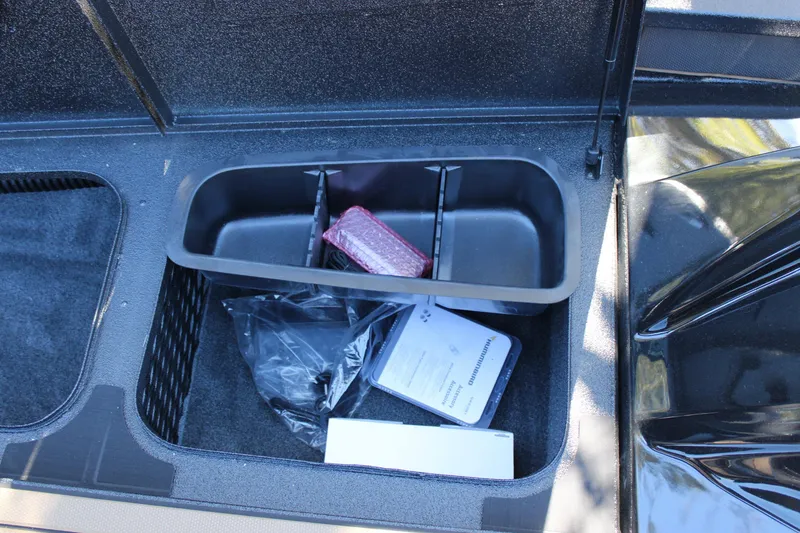 Slide: The Image of Storage compartment of 2026 Xpress X21 Pro boat with manuals and accessories. - 16