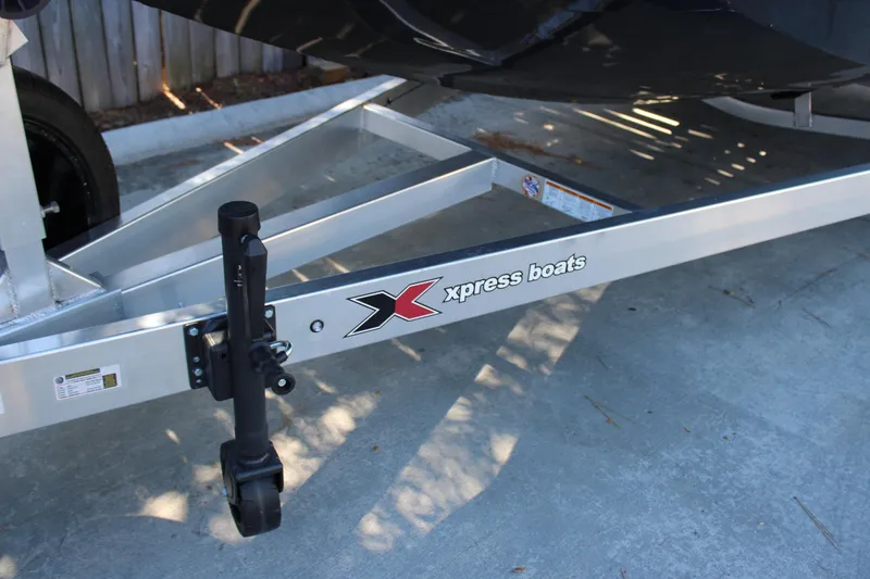 Slide: The Image of Trailer of 2026 Xpress X21 Pro boat with logo, parked on concrete. - 23