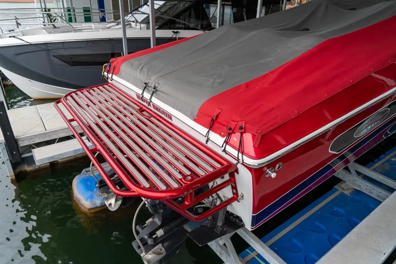 Slide: The Image of 2000 Baja 36 Outlaw boat with red cover docked in marina. - 10
