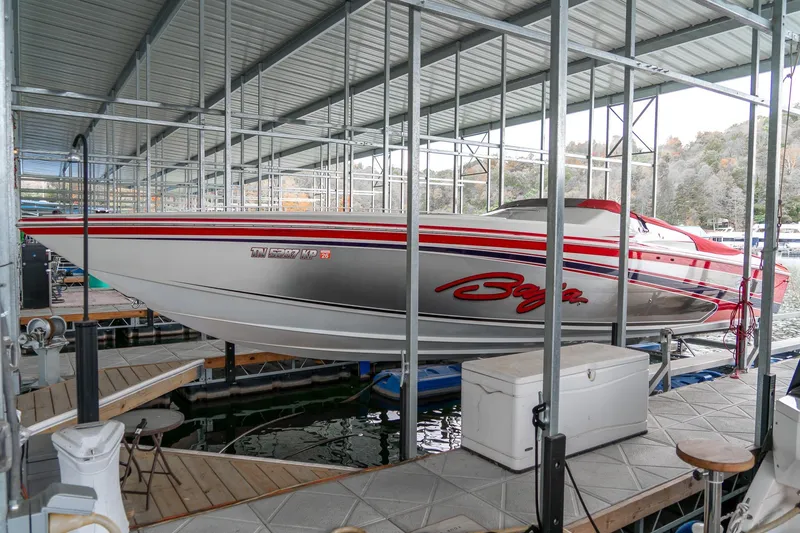 Slide: The Image of 2000 Baja 36 Outlaw speedboat docked in a covered marina. - 11