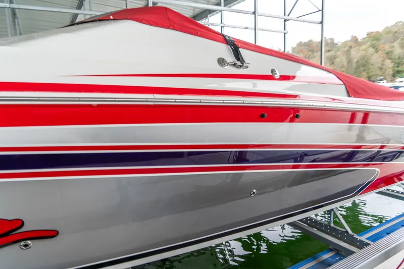 Slide: The Image of 2000 Baja 36 Outlaw boat with red and white stripes docked in a marina. - 15