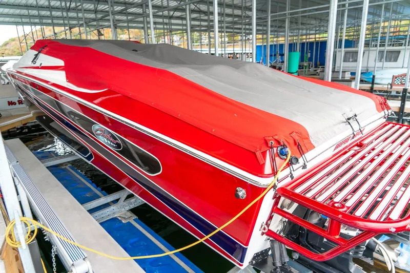 Slide: The Image of Red 2000 Baja 36 Outlaw speedboat docked under a covered marina. - 17