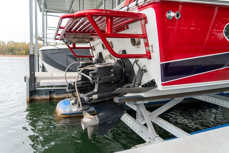 Slide: The Image of 2000 Baja 36 Outlaw boat on lift, showcasing red exterior and propeller. - 20