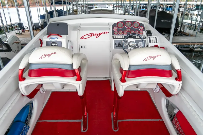 Slide: The Image of 2000 Baja 36 Outlaw boat cockpit with red and white seating and dashboard. - 27