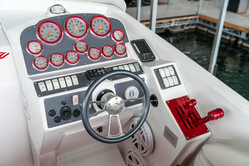Slide: The Image of Cockpit of 2000 Baja 36 Outlaw boat with gauges, steering wheel, and controls. - 30