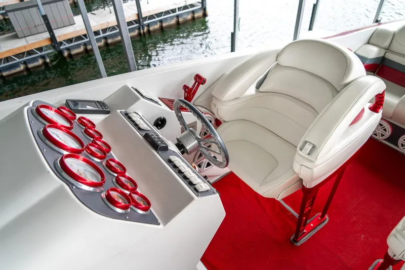 Slide: The Image of Interior of a 2000 Baja 36 Outlaw boat with white seating and red accents. - 36