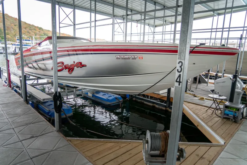 Slide: The Image of 2000 Baja 36 Outlaw speedboat docked in a covered marina. - 4