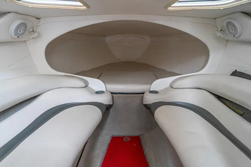Slide: The Image of Interior of a 2000 Baja 36 Outlaw boat, featuring sleek white seating and speakers. - 44