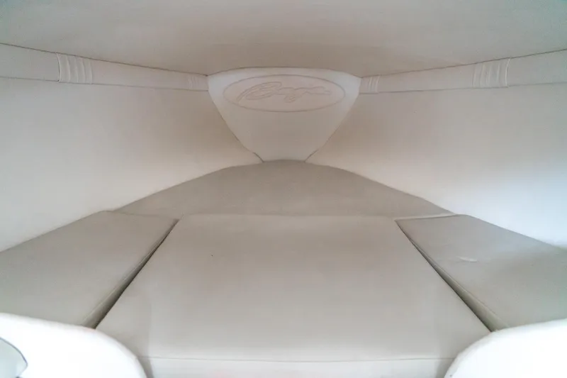 Slide: The Image of Interior cabin of a 2000 Baja 36 Outlaw boat, featuring white cushioned seating. - 45