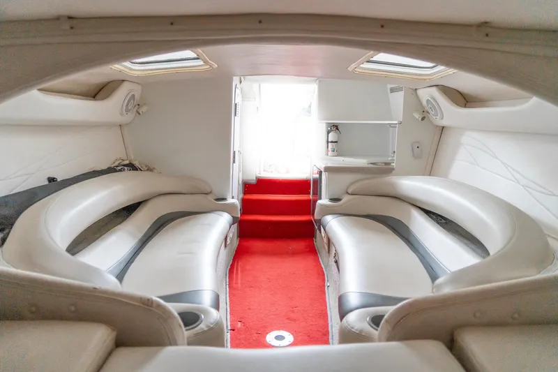 Slide: The Image of Interior of 2000 Baja 36 Outlaw boat with red carpet and white seating. - 46
