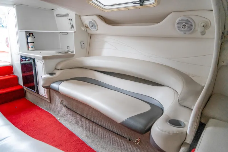 Slide: The Image of Interior of a 2000 Baja 36 Outlaw boat with red carpet and white seating. - 47