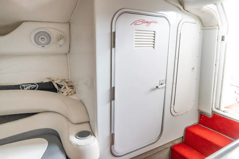 Slide: The Image of Interior of 2000 Baja 36 Outlaw boat with white seating and red carpeted stairs. - 50