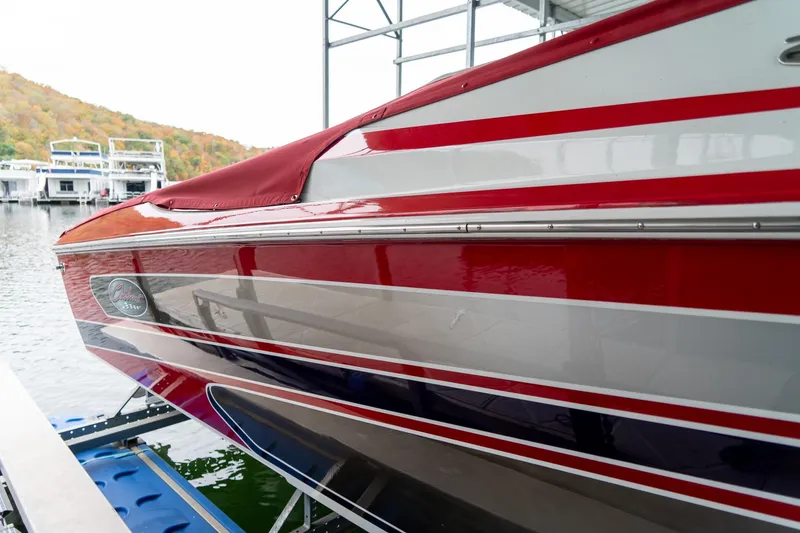 Slide: The Image of 2000 Baja 36 Outlaw boat with red and white stripes docked by the water. - 6