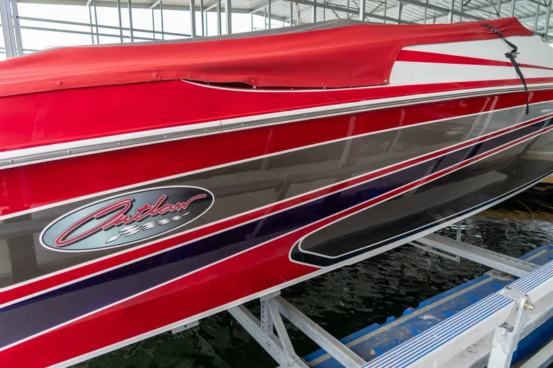 Slide: The Image of Red 2000 Baja 36 Outlaw boat with sleek design on a lift. - 7