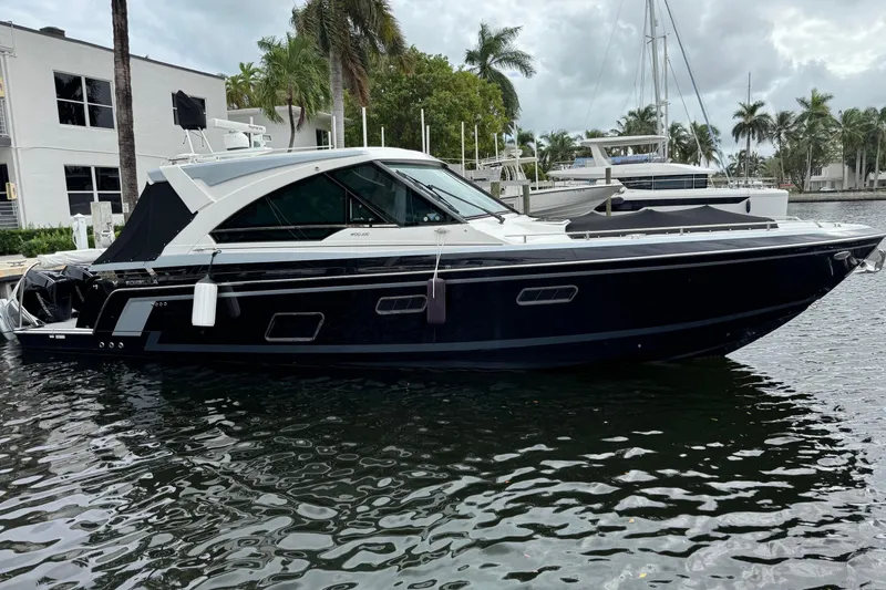 Slide: The Image of 2023 Formula 400 Super Sport Crossover yacht docked in a marina with palm trees. - 2