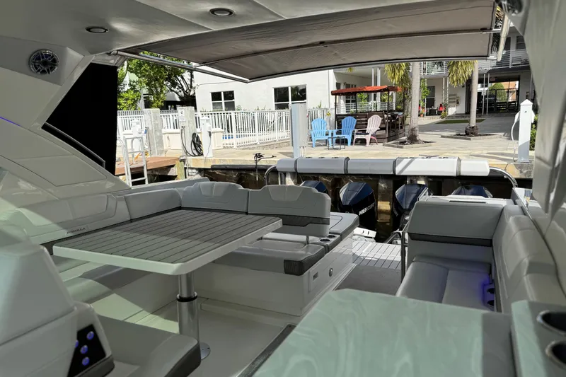 Slide: The Image of 2023 Formula 400 Super Sport Crossover yacht interior with seating and table, docked at marina. - 26