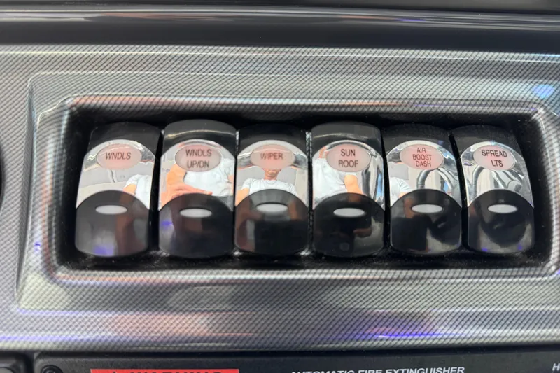 Slide: The Image of Control panel switches on a 2023 Formula 400 Super Sport Crossover boat dashboard. - 38