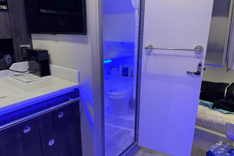Slide: The Image of 2023 Formula 400 Super Sport Crossover interior with modern bathroom and ambient blue lighting. - 70