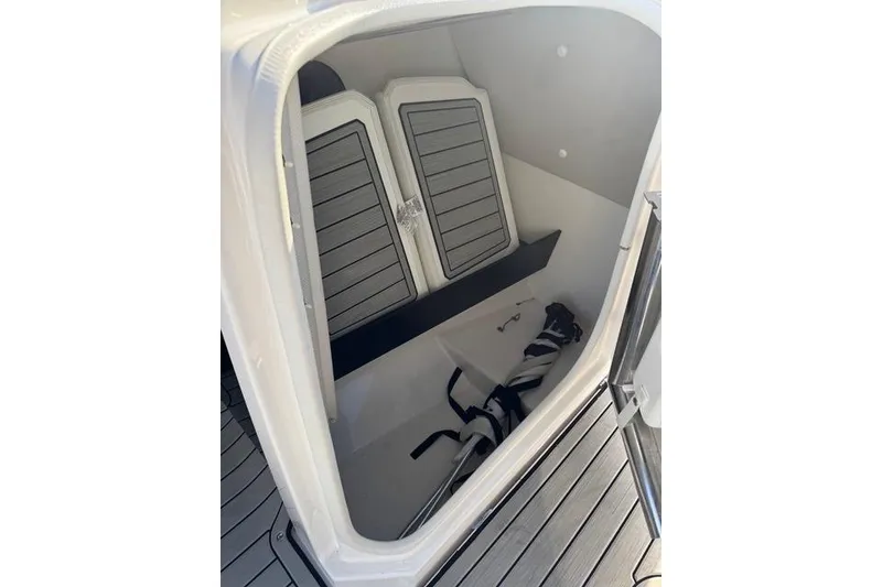 Slide: The Image of 2021 Yamaha Boats 252SE storage compartment with cushions and equipment. - 10