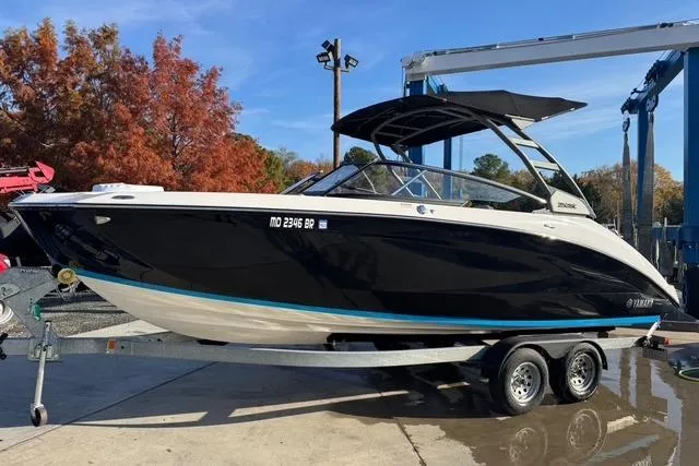 Slide: The Image of 2021 Yamaha Boats 252SE on trailer, black hull, outdoor setting. - 4