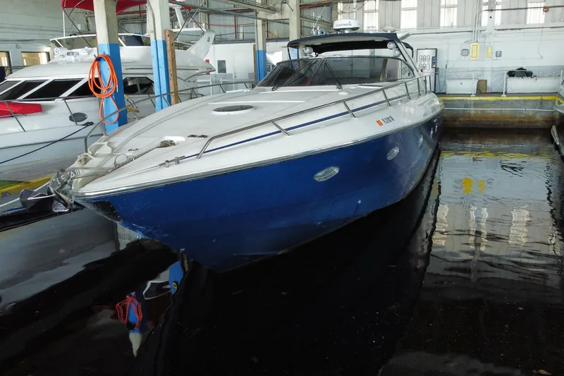 Slide: The Image of 1997 Sunseeker Camargue 51 yacht docked in a marina, featuring a sleek blue hull. - 1