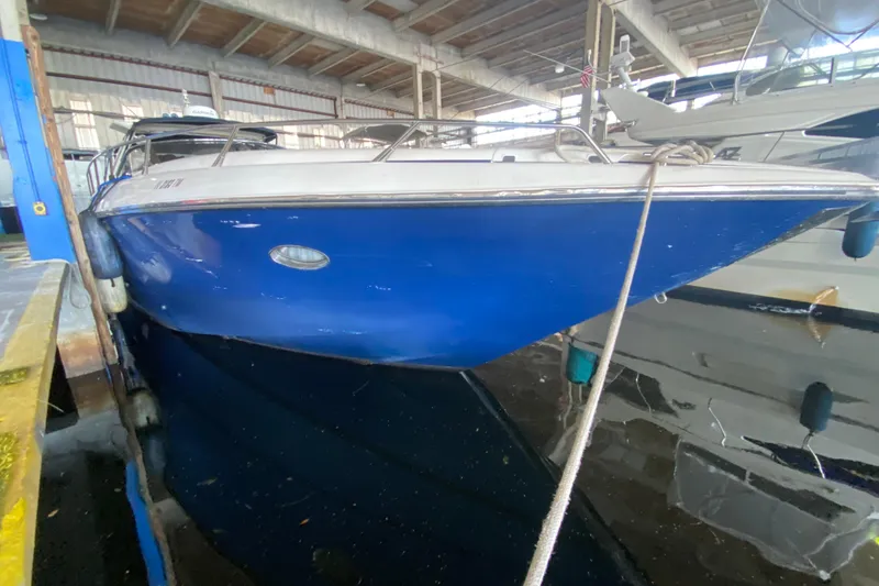 Slide: The Image of 1997 Sunseeker Camargue 51 yacht with blue hull docked indoors. - 10