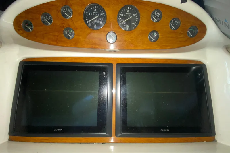 Slide: The Image of 1997 Sunseeker Camargue 51 dashboard with Garmin displays and analog gauges. - 32