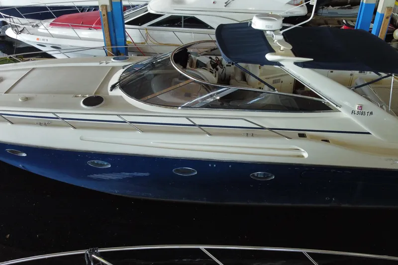 Slide: The Image of 1997 Sunseeker Camargue 51 yacht with blue hull, docked in a marina. - 8