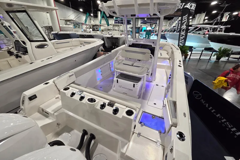 Slide: The Image of 2026 Sailfish 252 CC boat interior at a boat show, featuring modern design and lighting. - 18