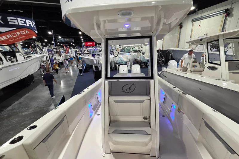 Slide: The Image of 2026 Sailfish 252 CC boat interior at a boat show, featuring modern seating and lighting. - 21