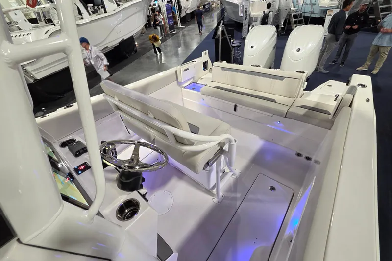 Slide: The Image of 2026 Sailfish 252 CC boat interior with modern seating and steering wheel at a boat show. - 22