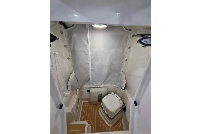 Slide: The Image of 2026 Sailfish 252 CC boat interior with compact toilet and wooden flooring. - 28