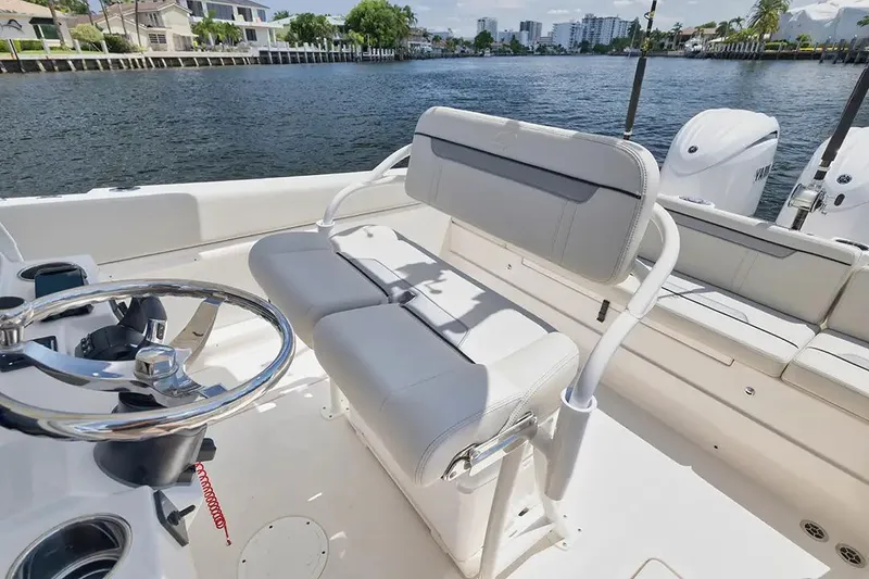 Slide: The Image of Manufacturer Provided Image: 2026 Sailfish 252 CC boat interior with steering wheel and seating, docked by waterfront homes. - 7