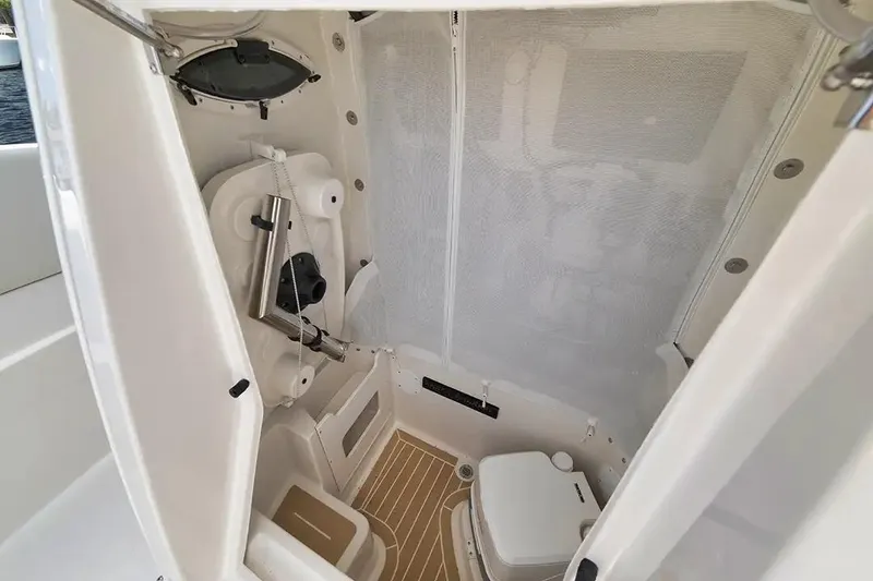 Slide: The Image of Manufacturer Provided Image: Interior of 2026 Sailfish 252 CC boat, featuring compact marine toilet and storage. - 9