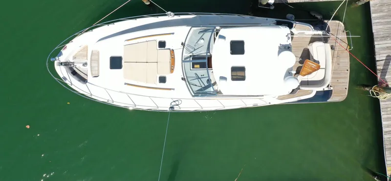 Slide: The Image of Aerial view of 2006 Chris-Craft 43 Roamer yacht docked in green water. - 1