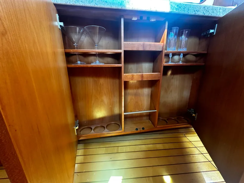 Slide: The Image of Open wooden cabinet with glassware storage on a 2006 Chris-Craft 43 Roamer yacht. - 32
