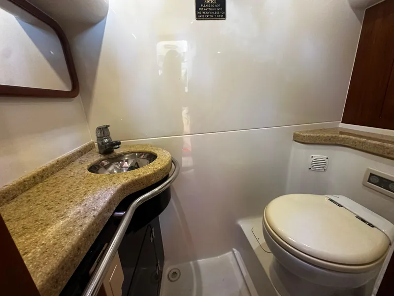 Slide: The Image of 2006 Chris-Craft 43 Roamer cabin with twin beds, elegant wood paneling, and soft lighting. - 36