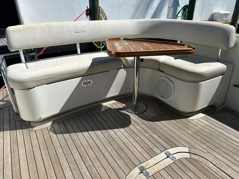 Slide: The Image of 2006 Chris-Craft 43 Roamer yacht seating area with wooden table and cushioned benches. - 4