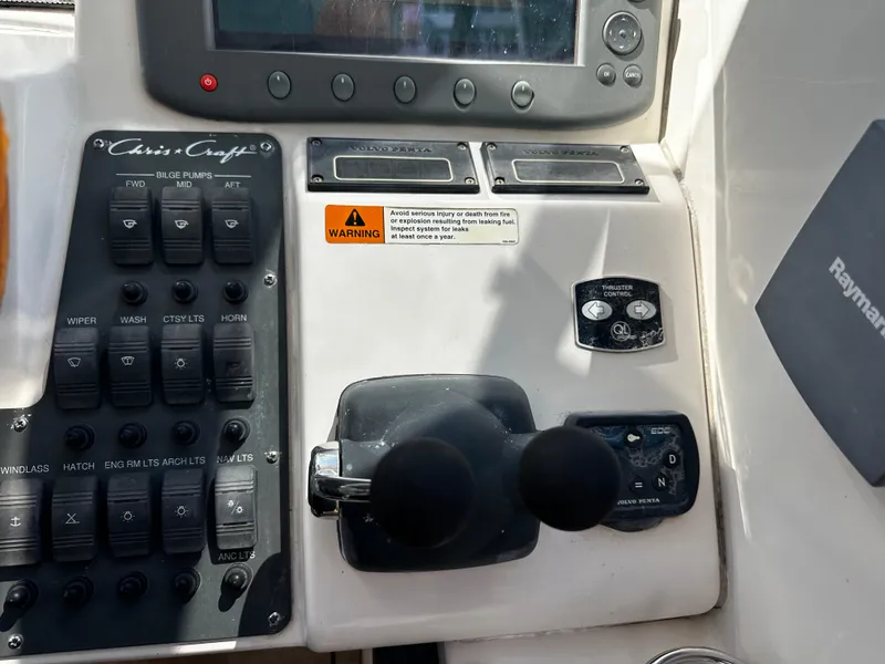 Slide: The Image of Control panel of a 2006 Chris-Craft 43 Roamer boat with switches and throttle levers. - 12