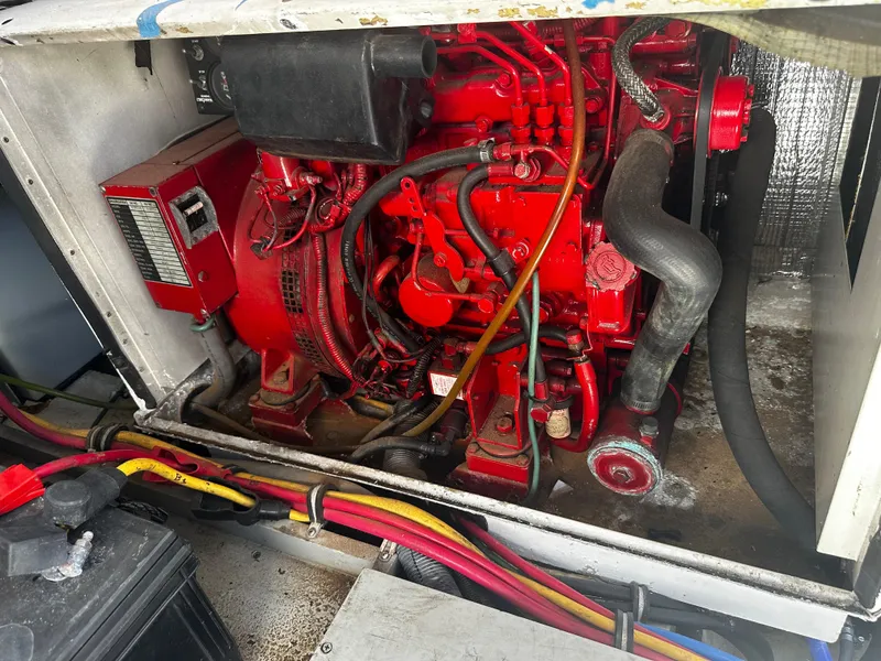 Slide: The Image of Engine compartment of a 2006 Chris-Craft 43 Roamer, featuring a red engine and wiring. - 18