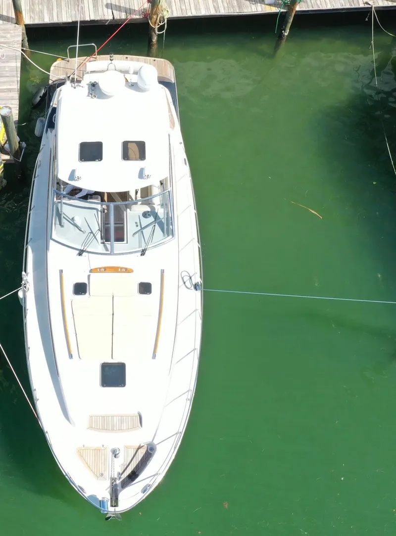 Slide: The Image of 2006 Chris-Craft 43 Roamer yacht docked in green water, aerial view. - 2