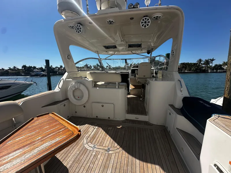 Slide: The Image of 2006 Chris-Craft 43 Roamer yacht interior with wooden deck and seating, docked by the water. - 3