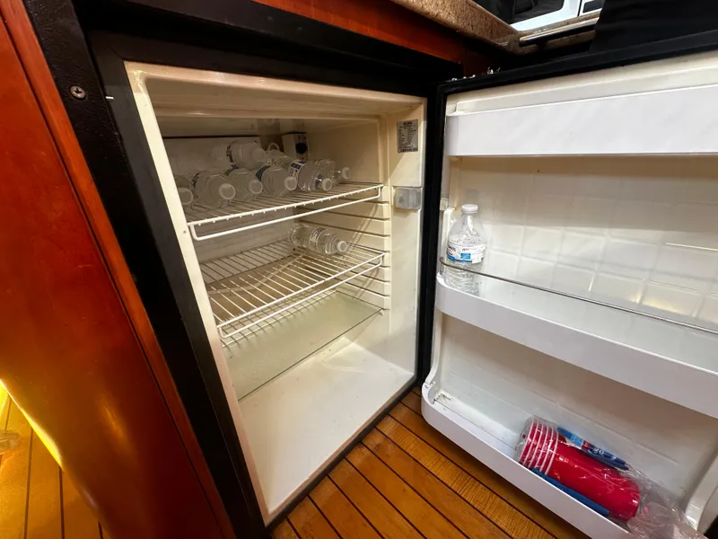 Slide: The Image of Open fridge on 2006 Chris-Craft 43 Roamer yacht, stocked with water bottles and cups. - 30
