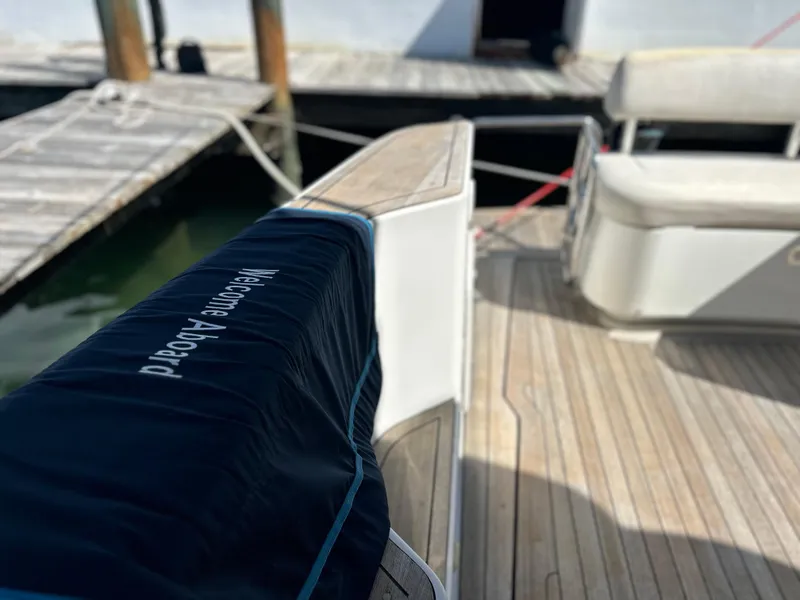 Slide: The Image of 2006 Chris-Craft 43 Roamer yacht deck with "Welcome Aboard" cover, docked at marina. - 5