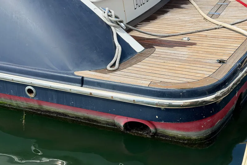 Slide: The Image of 2006 Chris-Craft Roamer 40 boat stern with wooden deck and mooring ropes. - 32