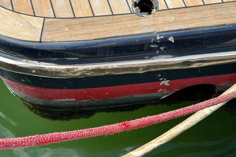 Slide: The Image of Close-up of 2006 Chris-Craft Roamer 40 boat hull with visible wear and dock lines. - 42
