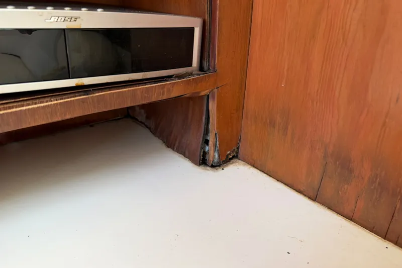 Slide: The Image of Damaged wood paneling near Bose equipment on 2006 Chris-Craft Roamer 40 yacht. - 36