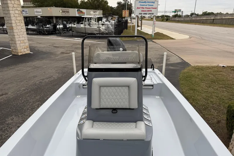 Slide: The Image of 2026 Blazer Bay 2220 Fisherman boat with sleek seating and console, parked outdoors. - 19